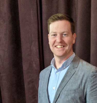 Seanr wearing a grey sport coat and blue shirt.